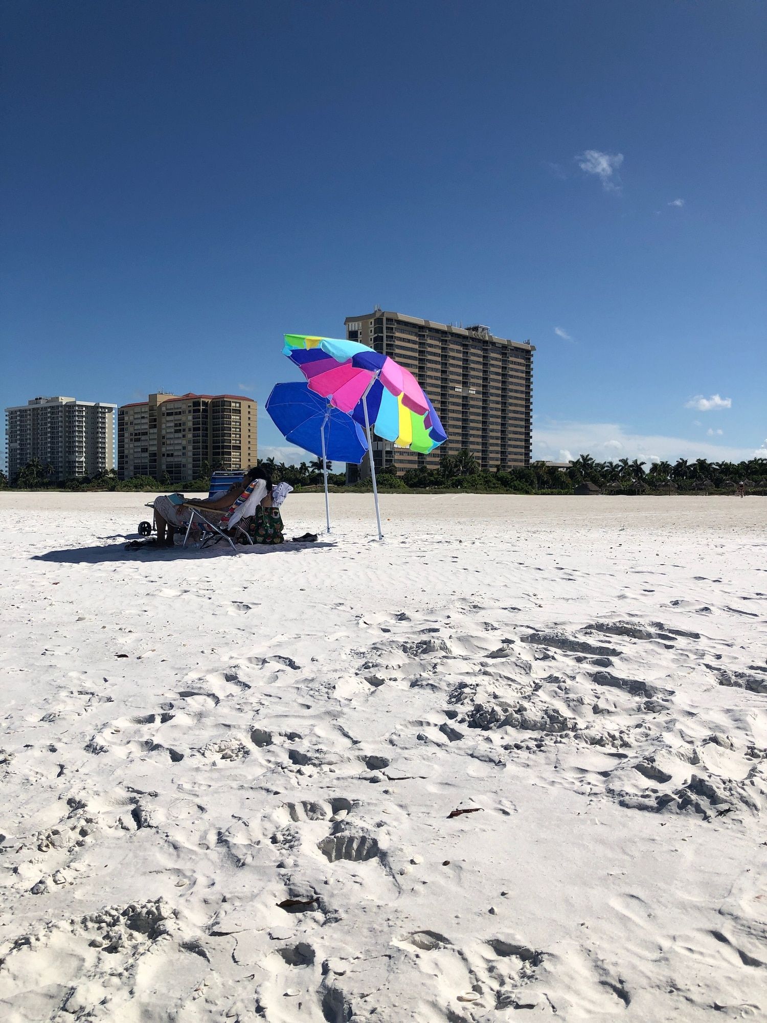 A couple of chairs and an umbrella on a beach.