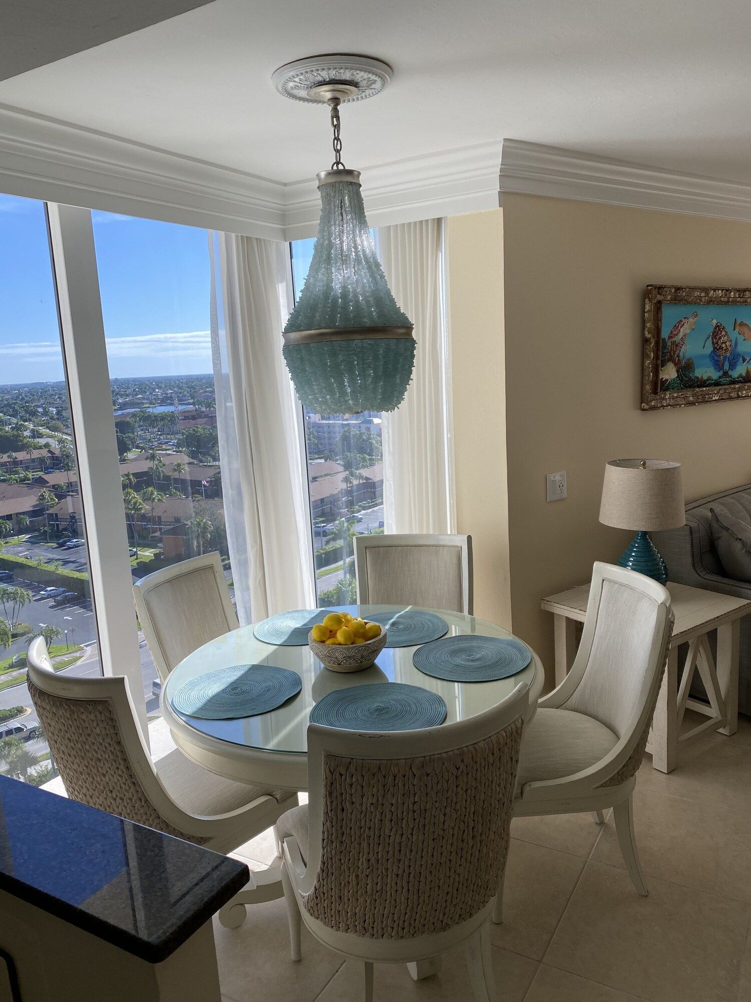 A dining room with a table and chairs and a chandelier hanging from the ceiling.