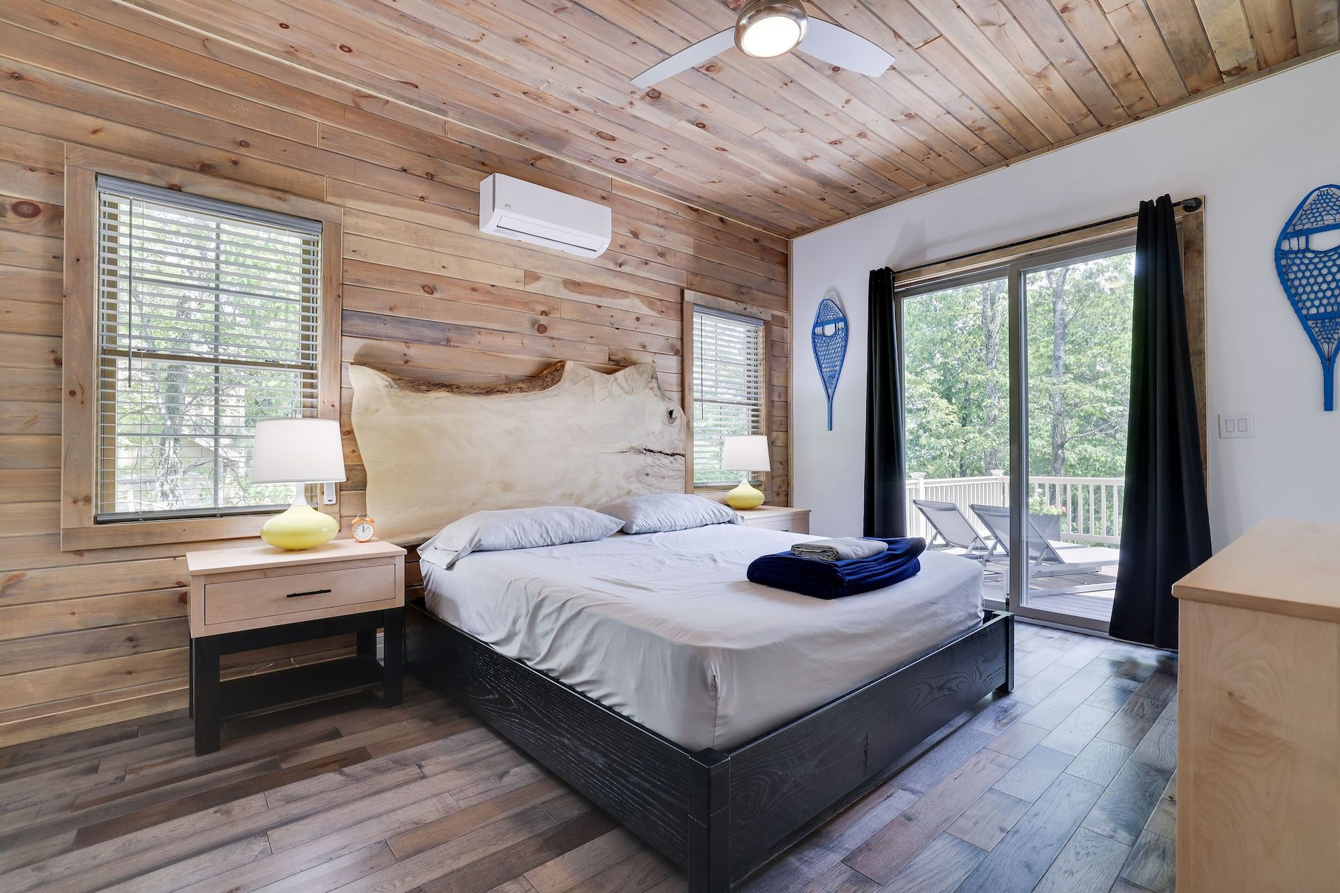 A bedroom with a king size bed and a sliding glass door.