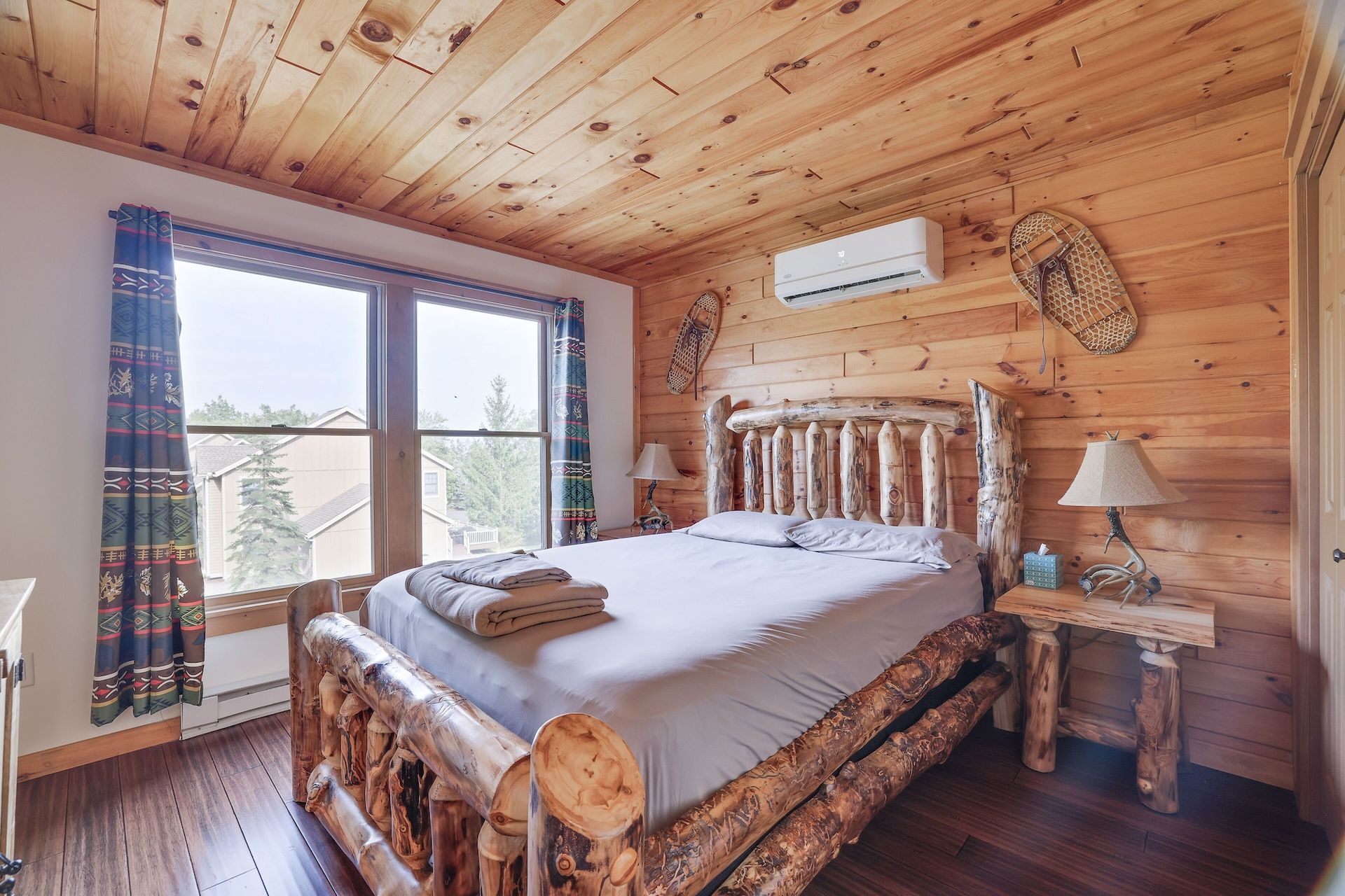 A bedroom in a log cabin with a king size log bed.