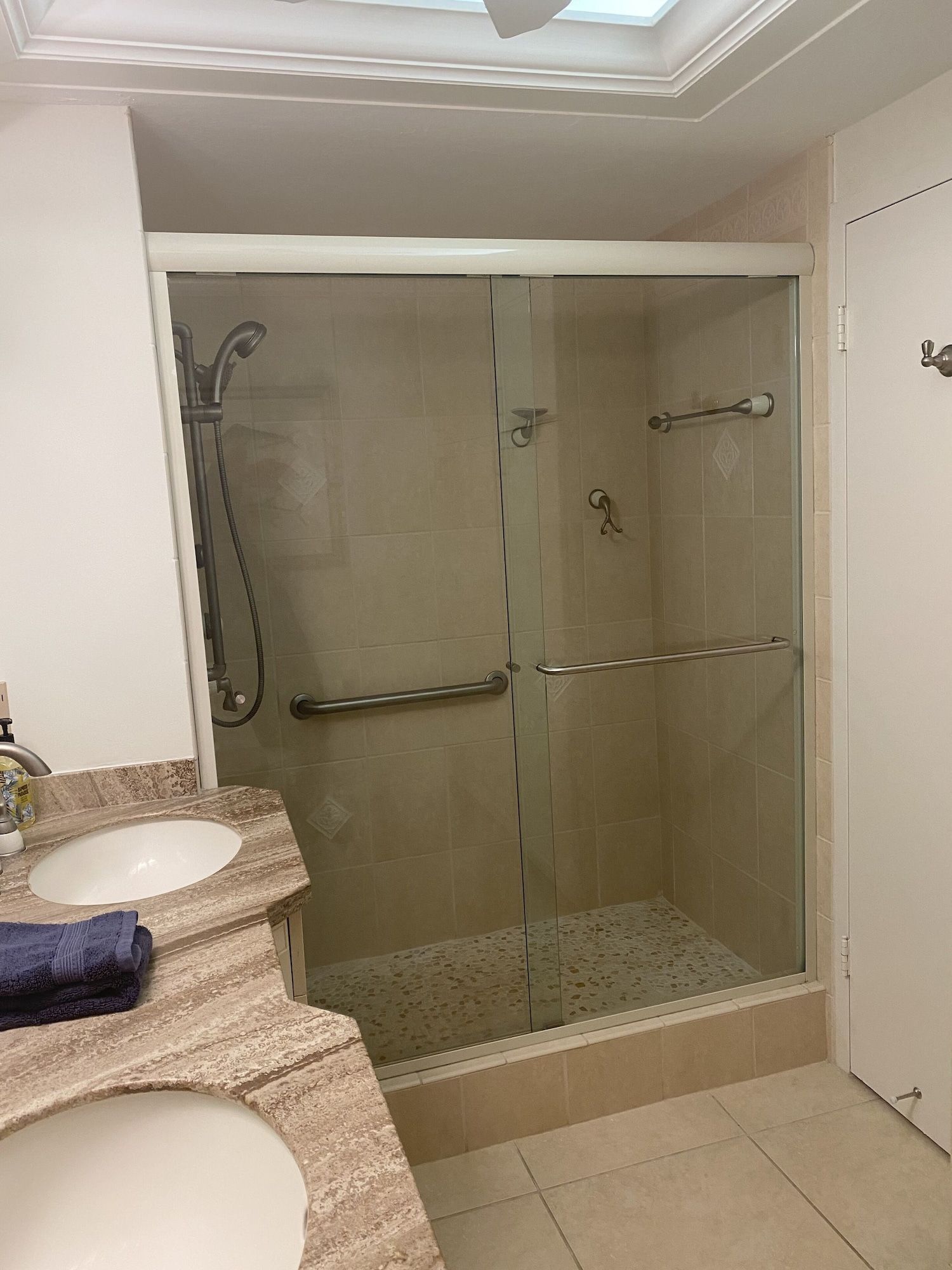 A bathroom with a sink and a walk in shower.