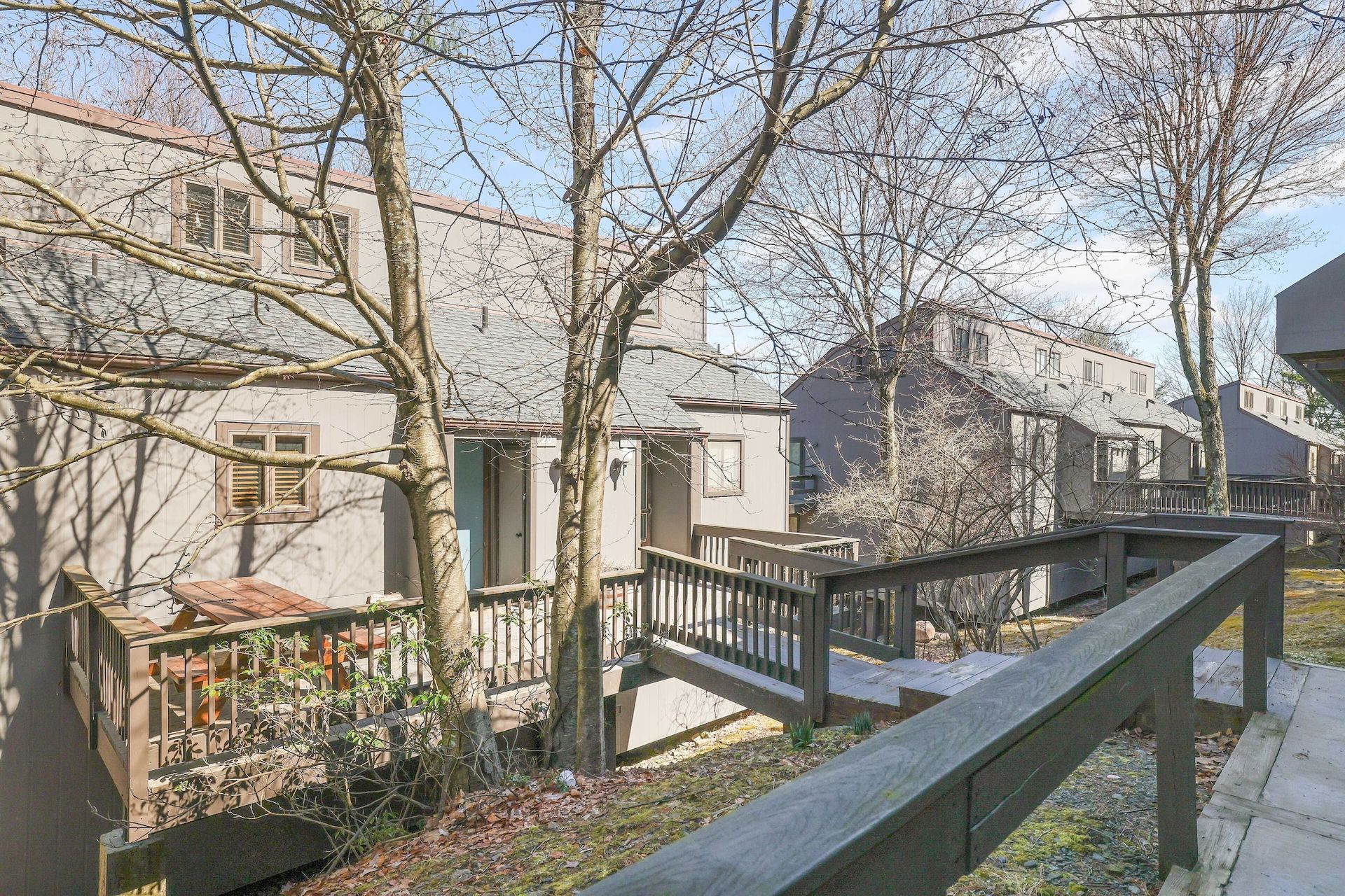 A view of a house from a balcony with trees in the background.