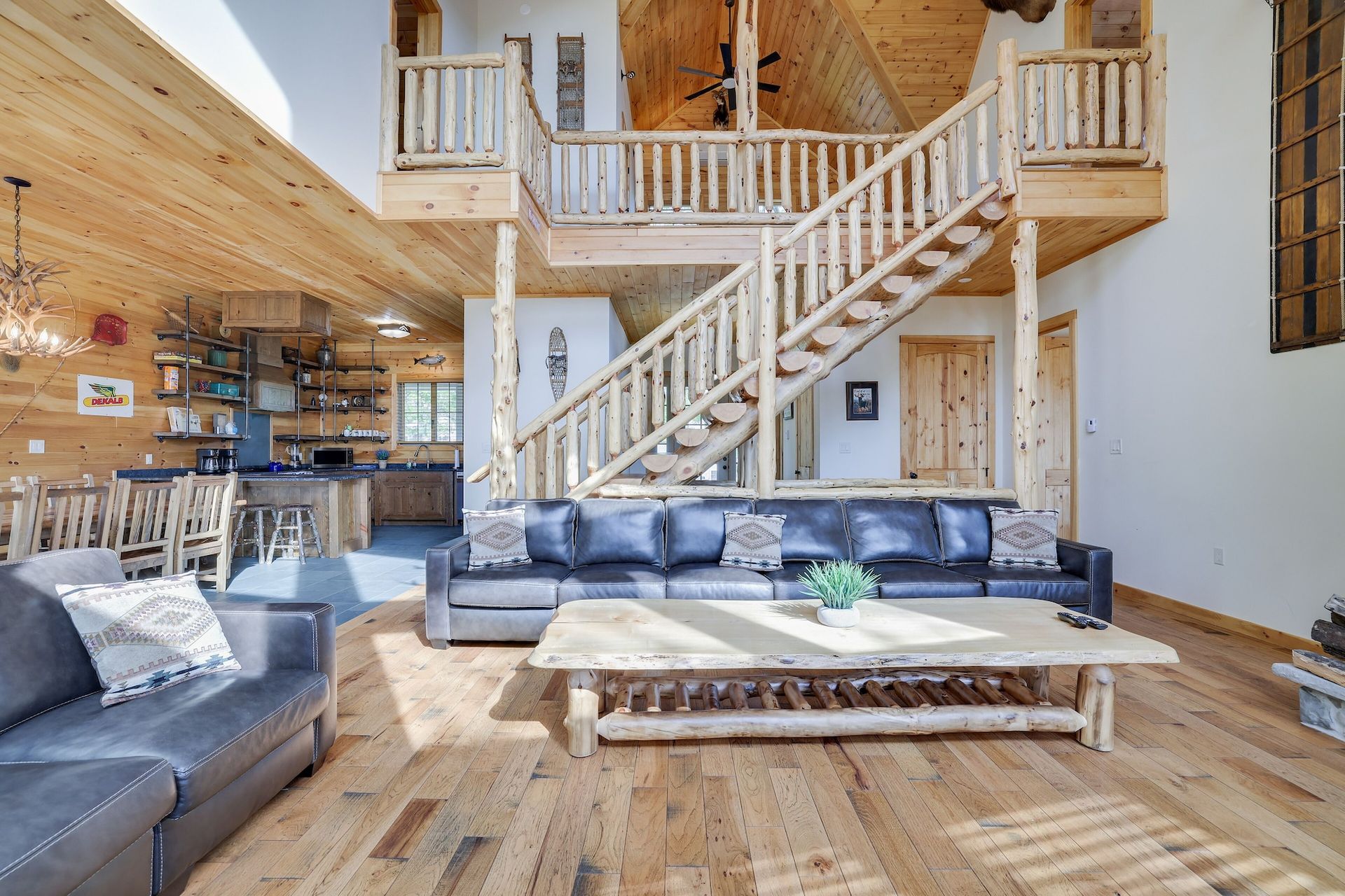 A living room in a log cabin with a staircase leading to the second floor.
