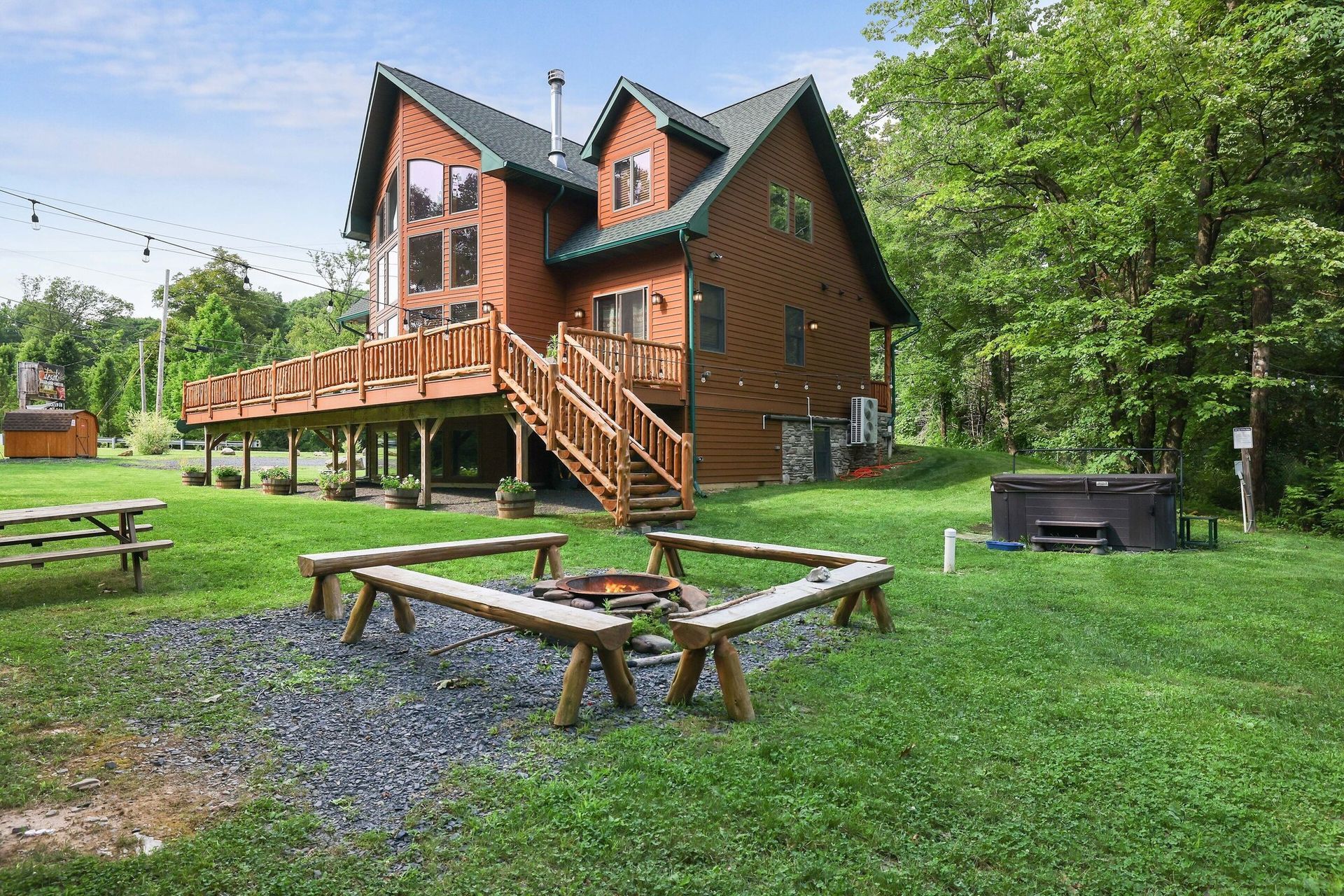 A large log cabin with a fire pit in front of it.