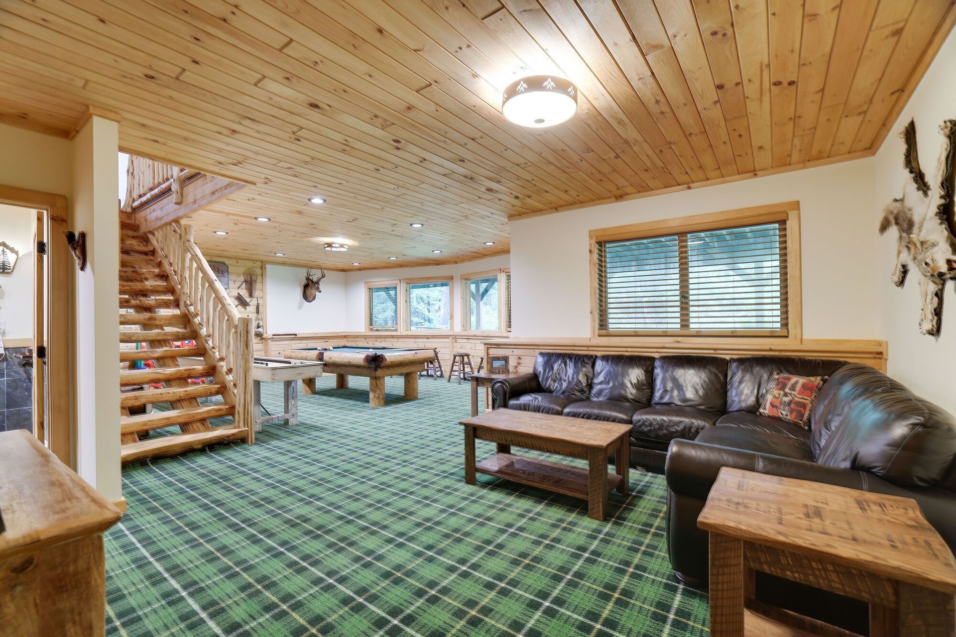 A living room with a couch , table , and pool table.