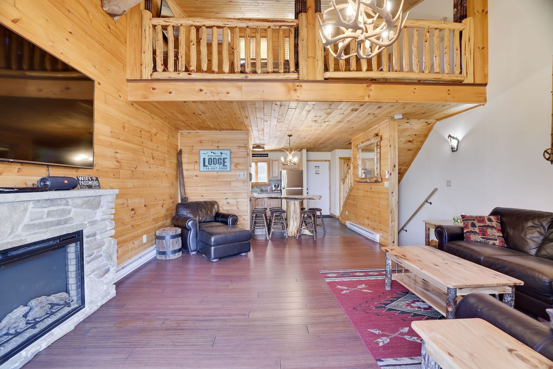 A living room filled with furniture and a fireplace in a log cabin.