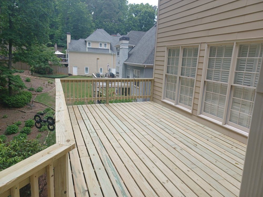 Wooden deck outside a house with a view of other houses and trees.