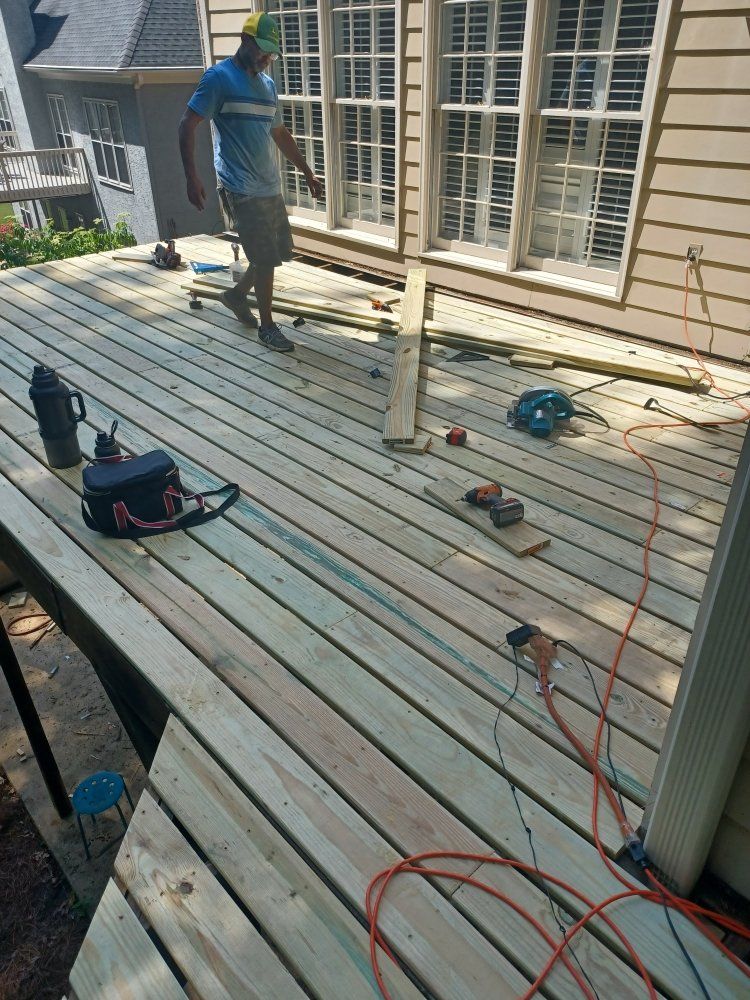 Person walking on a wooden deck under construction; tools and materials scattered around.