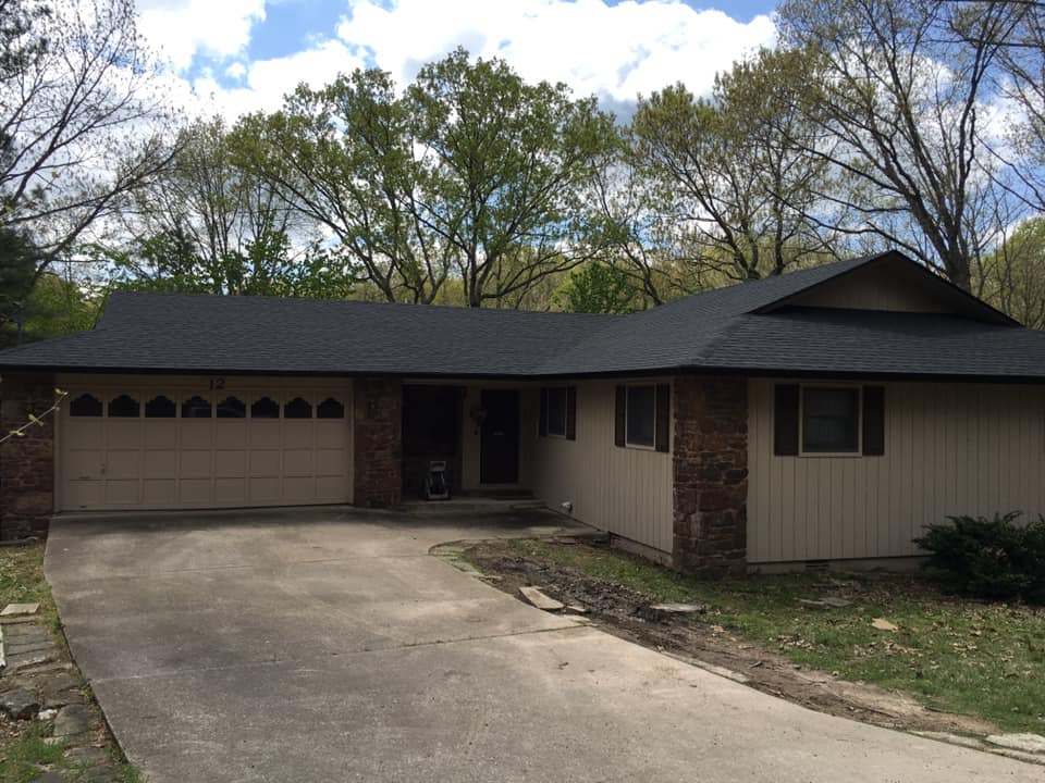 Single-story house with a two-car garage, brick and beige siding, and a curved concrete driveway.