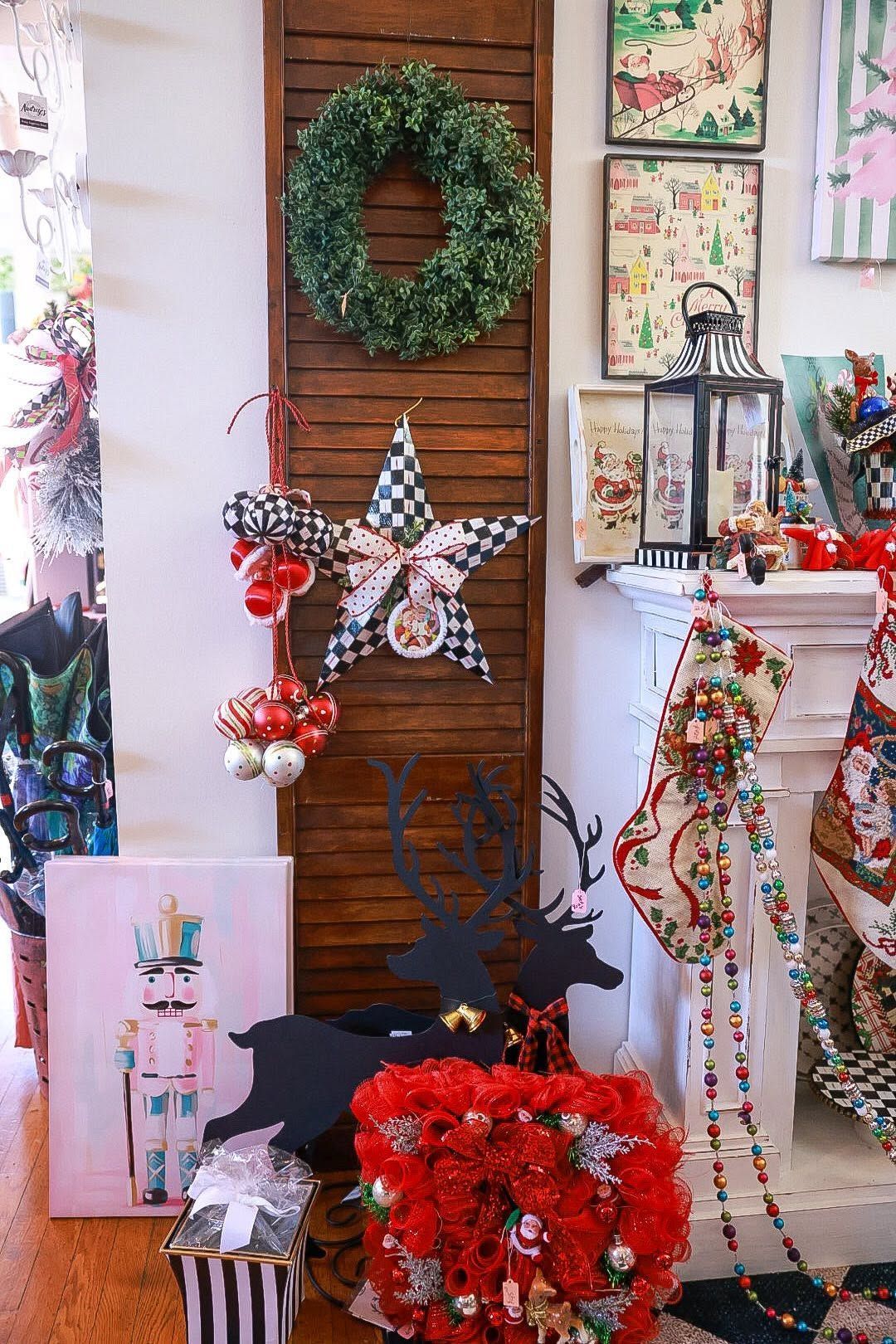 Holiday decorations displayed on a porch with wreaths, colorful garlands, and Santa figures