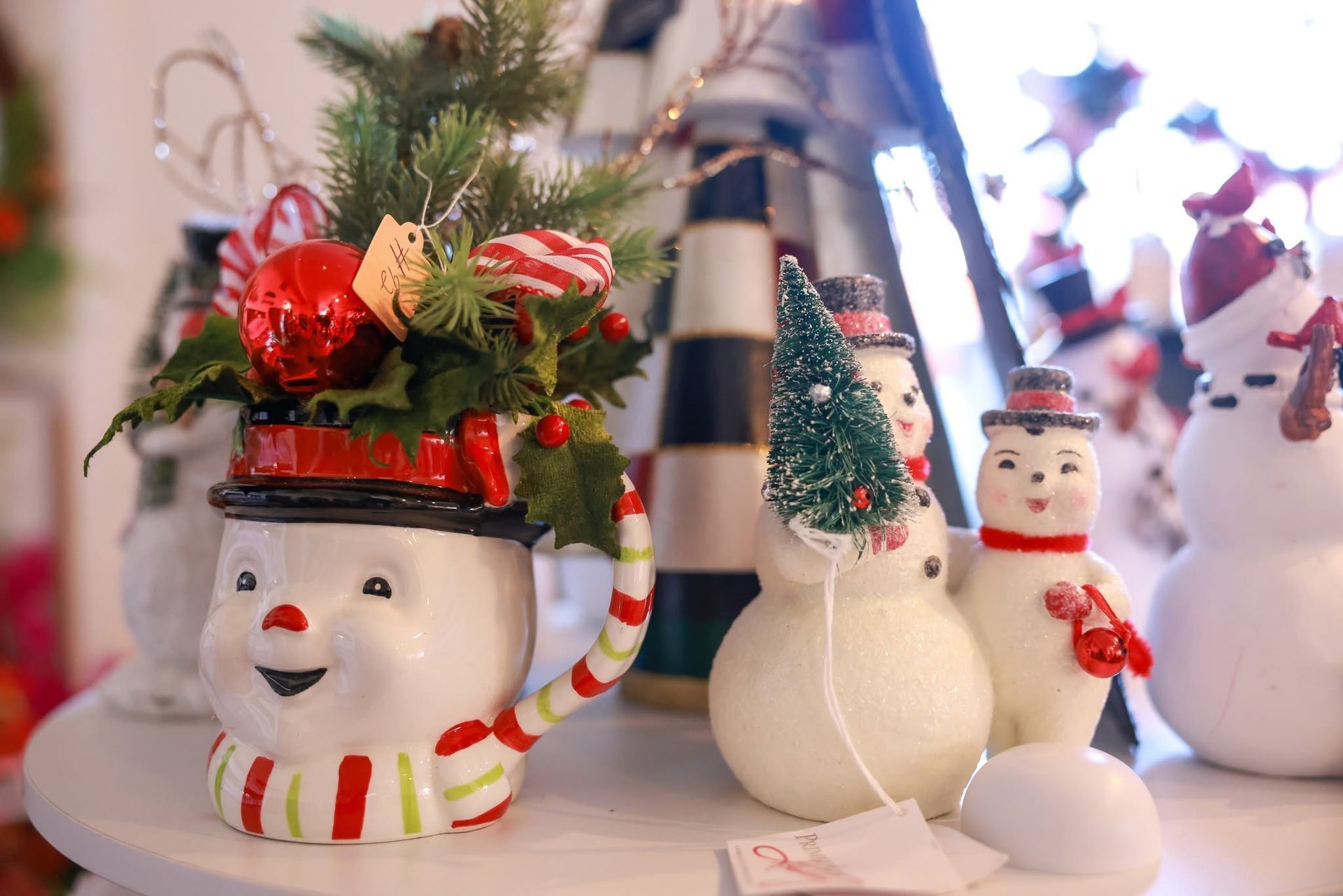 Festive snowman figurines with striped scarves and red holiday accents on a tabletop