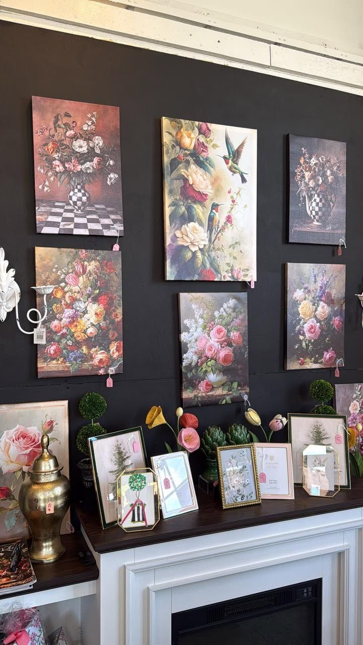 Floral artwork displayed above a white mantel with framed cards and decorative items underneath