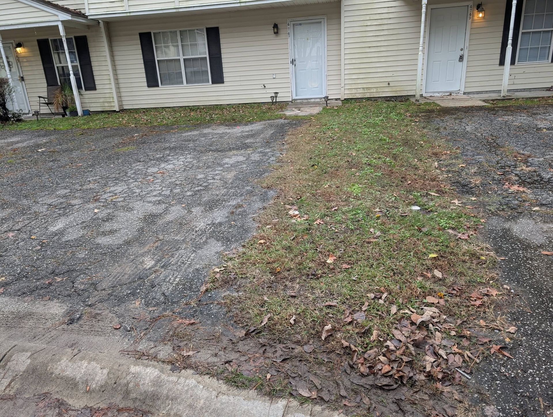 Duplex exterior with gravel driveways and a narrow grassy strip by the front doors