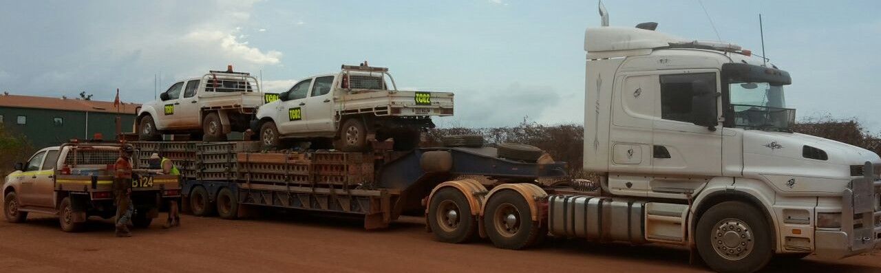 A Few Trcuks On Top Of A Larger Truck On A Muddy Roady WIth Some Workers Around — The Concreters in Edmonton, QLD