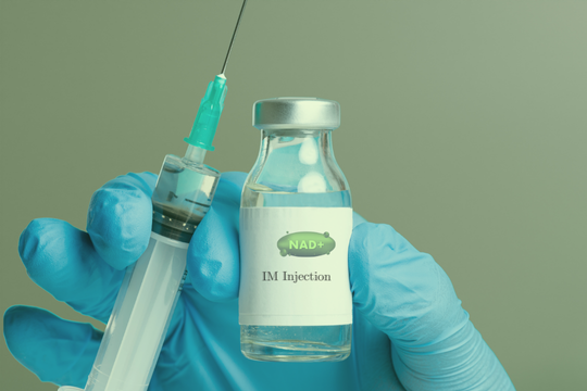 Gloved hand holding syringe beside vial labeled “IV Injection”
