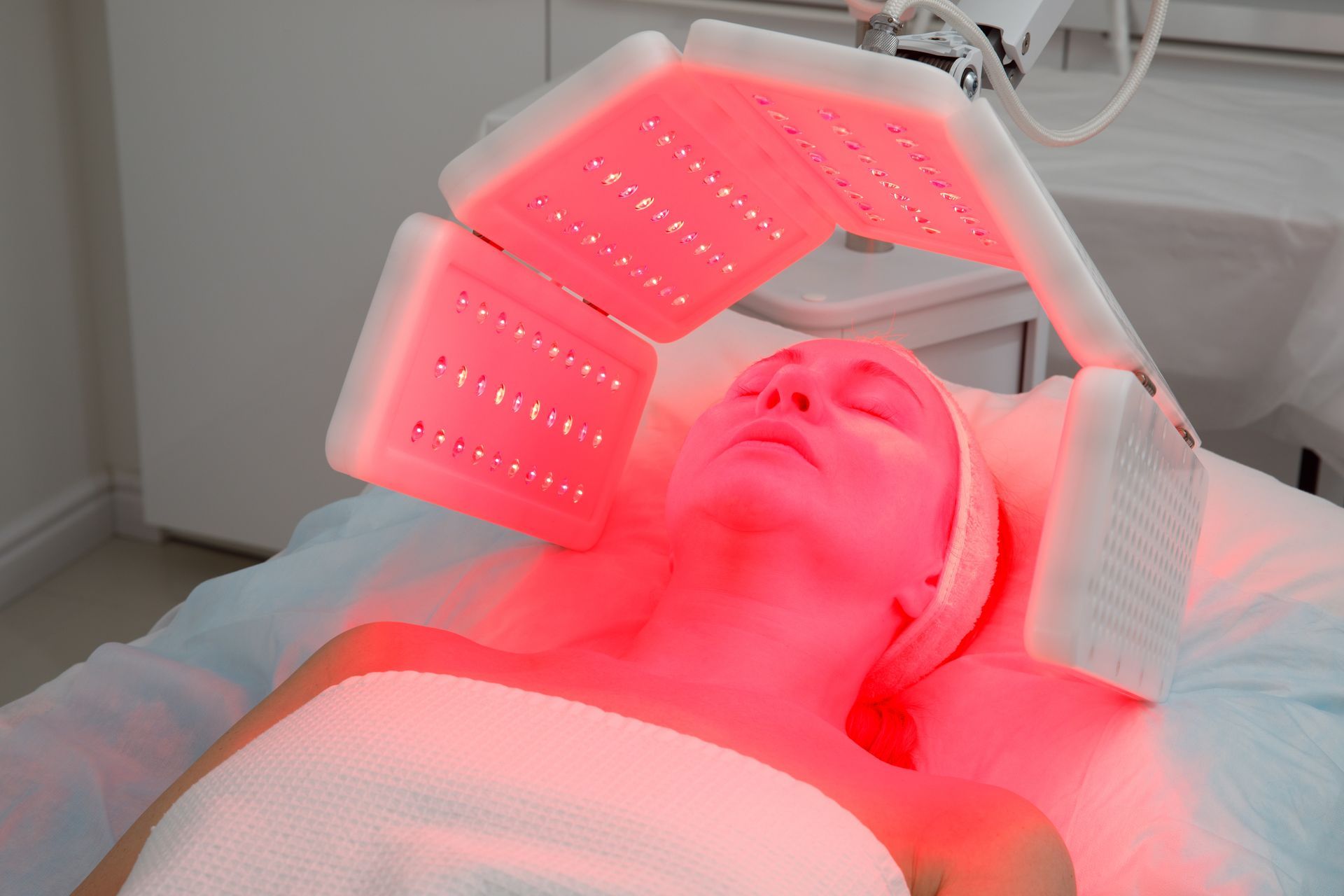 Person receiving red LED light therapy on a spa bed