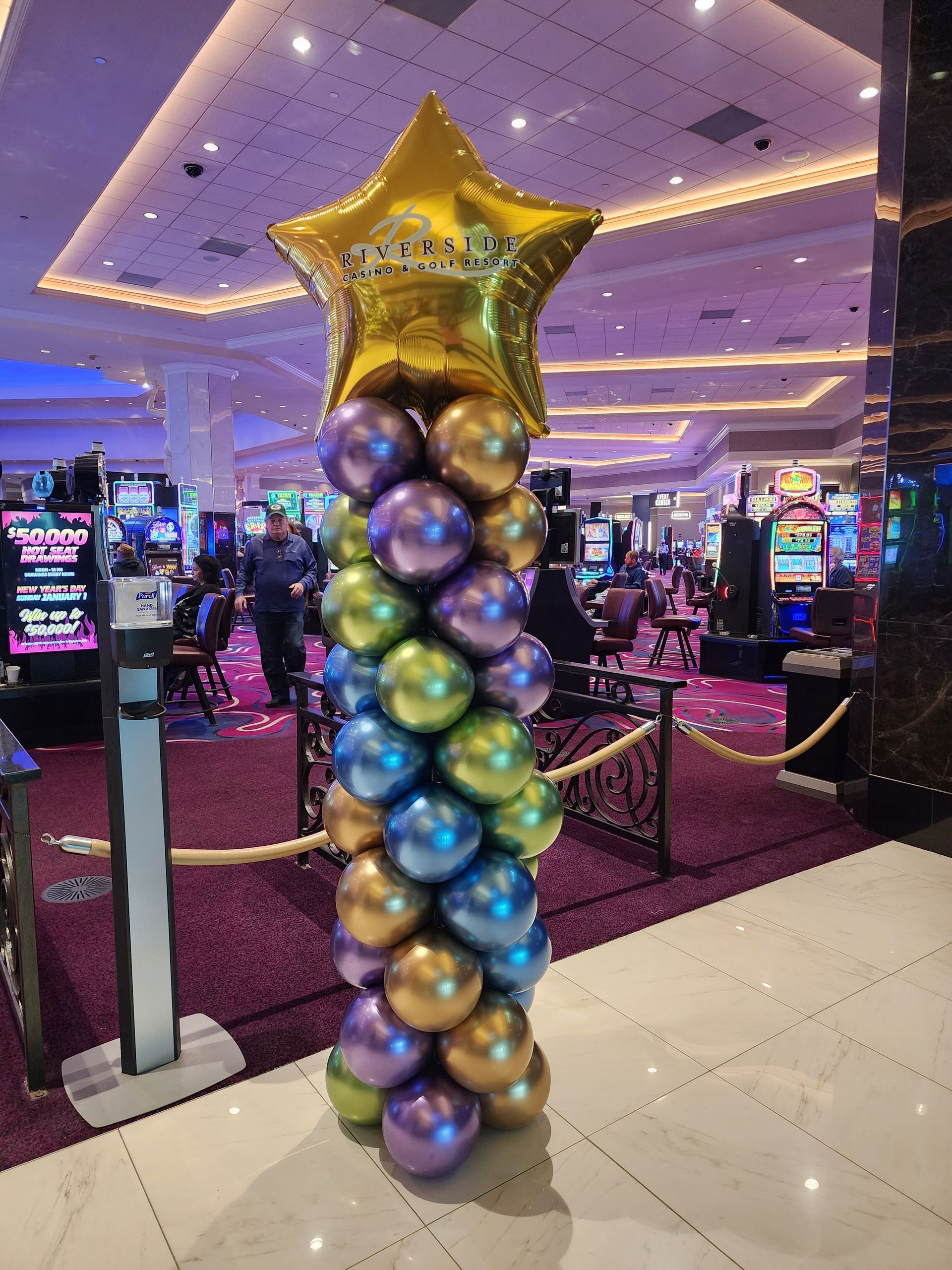 A column of balloons in a casino with a gold star on top.