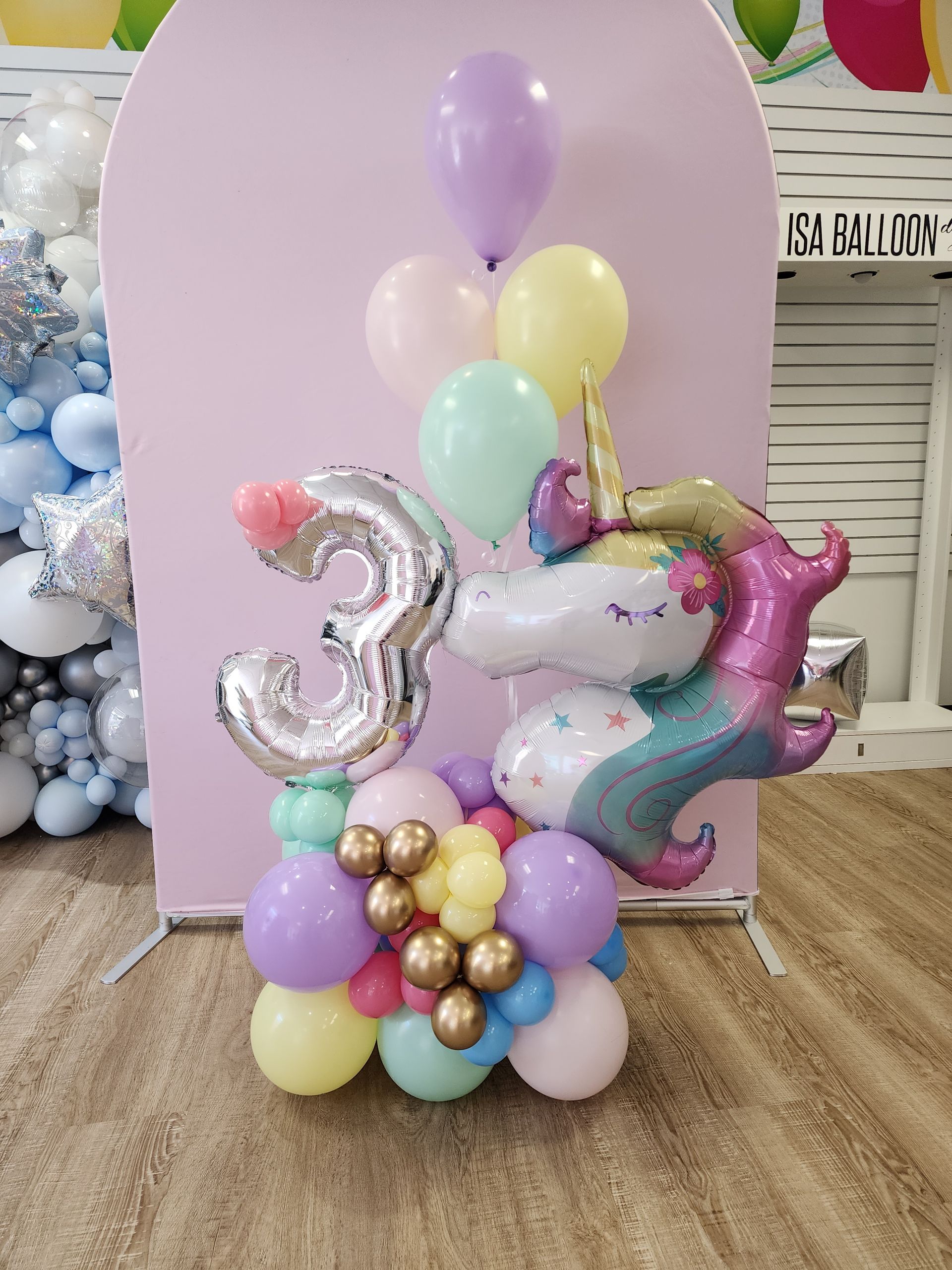 A bunch of balloons with a unicorn on top of them.