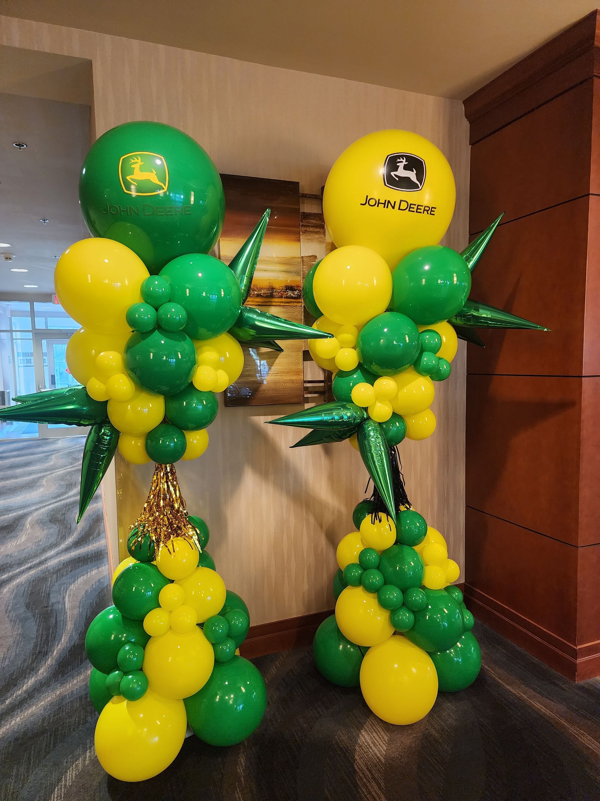 A bunch of green and yellow balloons with a john deere logo on them