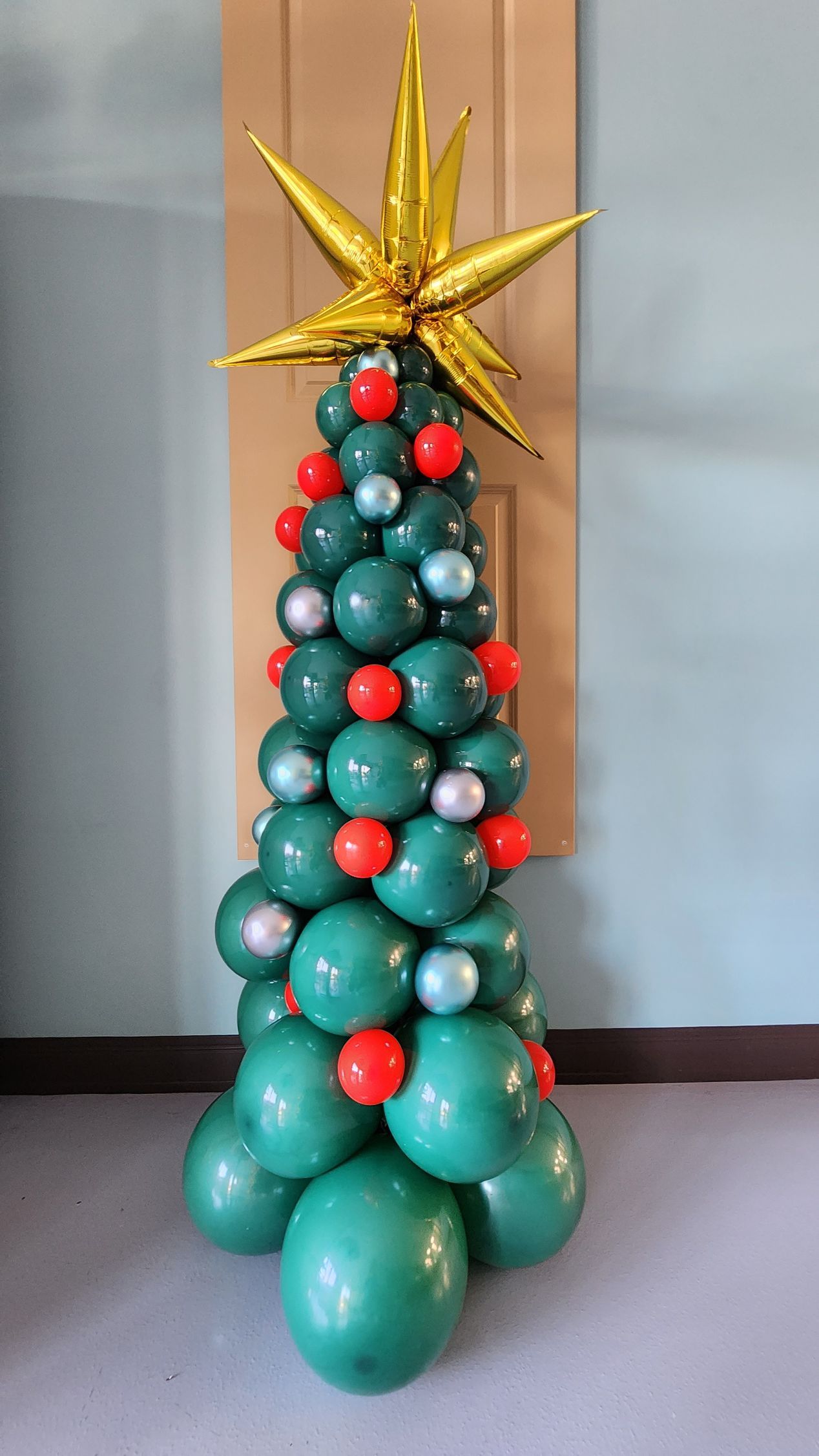 A christmas tree made out of balloons with a star on top.