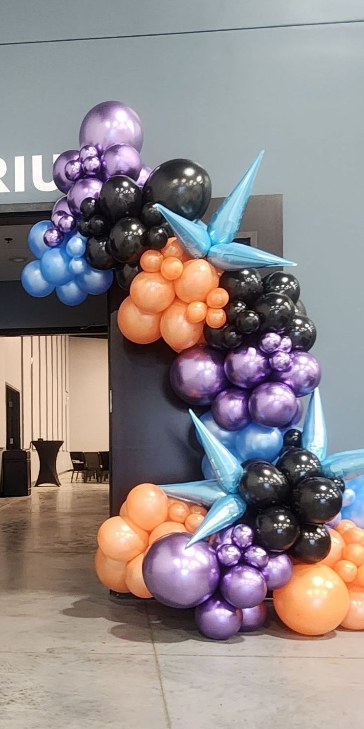 A bunch of balloons are sitting on the ground in front of a building.