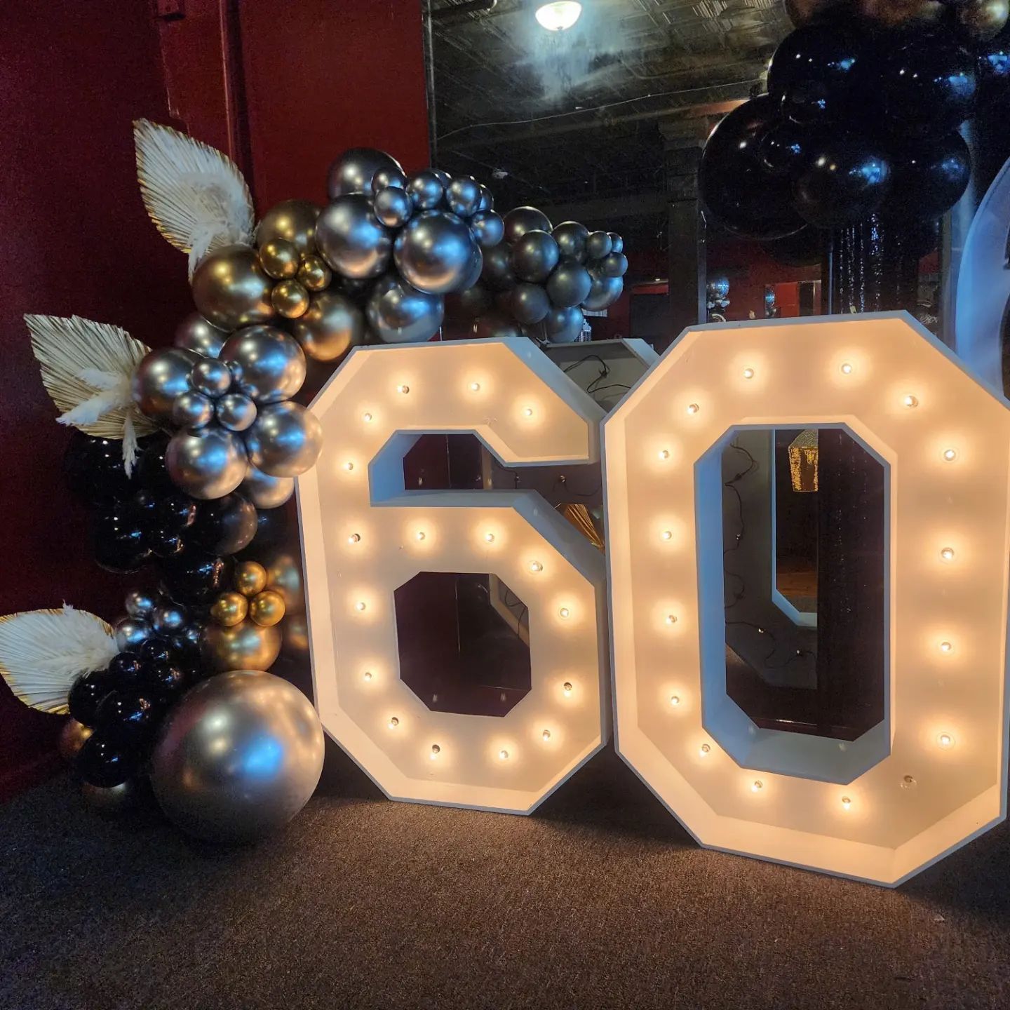The number 60 is lit up and surrounded by balloons