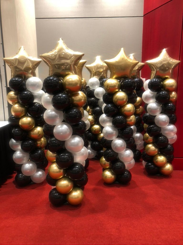 A bunch of balloons are stacked on top of each other on a red carpet.