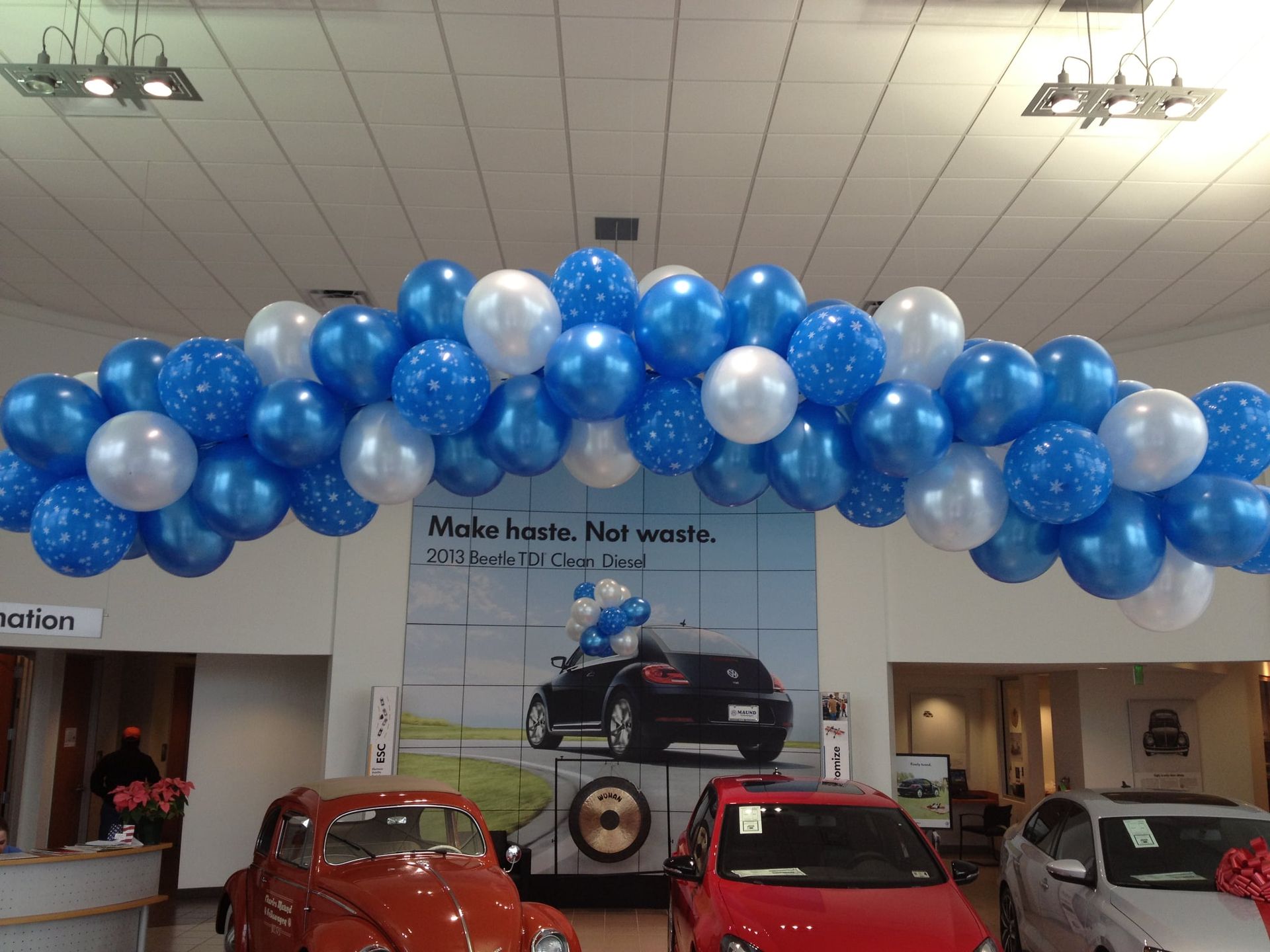 A bunch of blue and white balloons in a car dealership