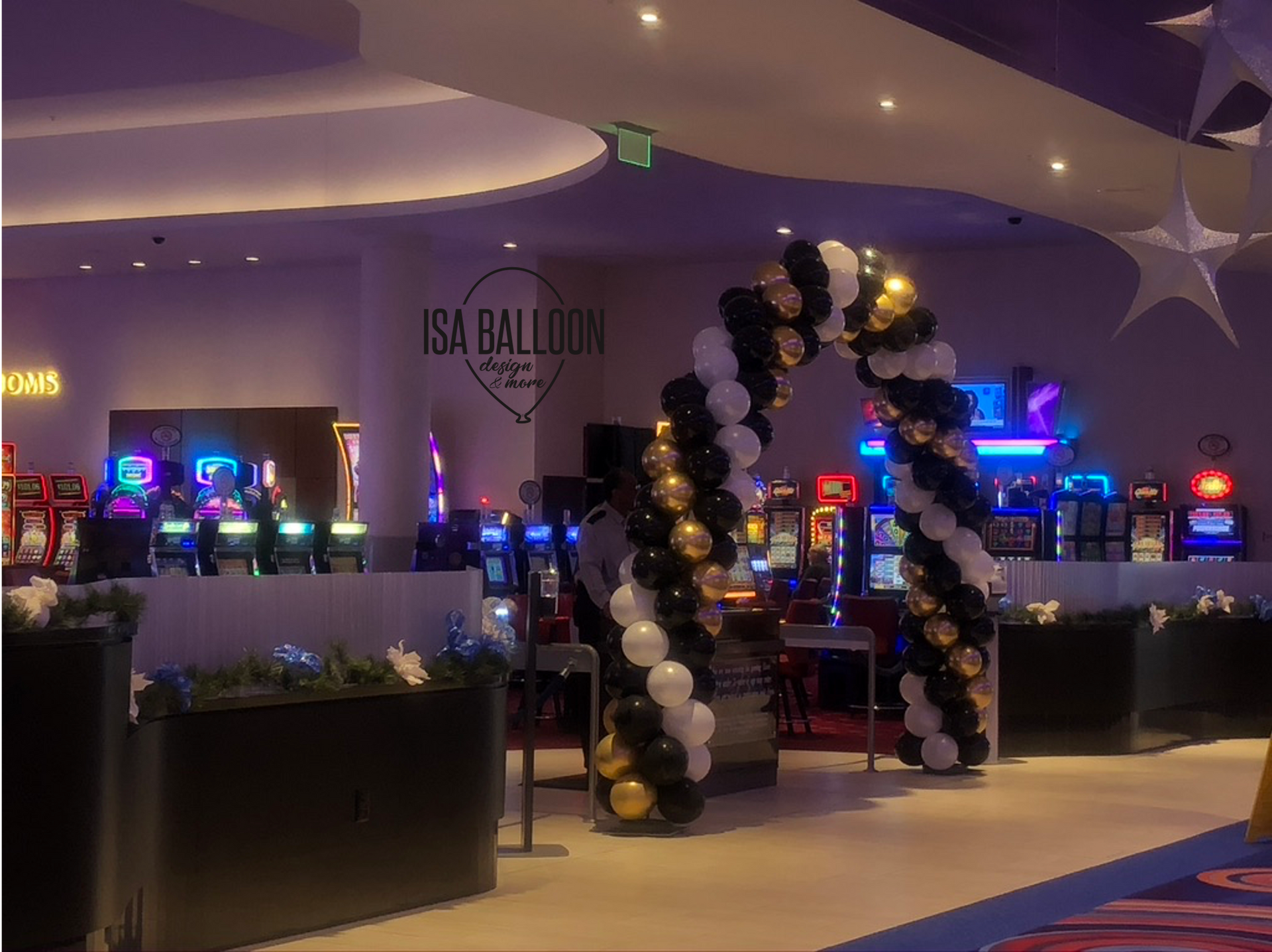 There is a large arch made of balloons in the middle of a casino.