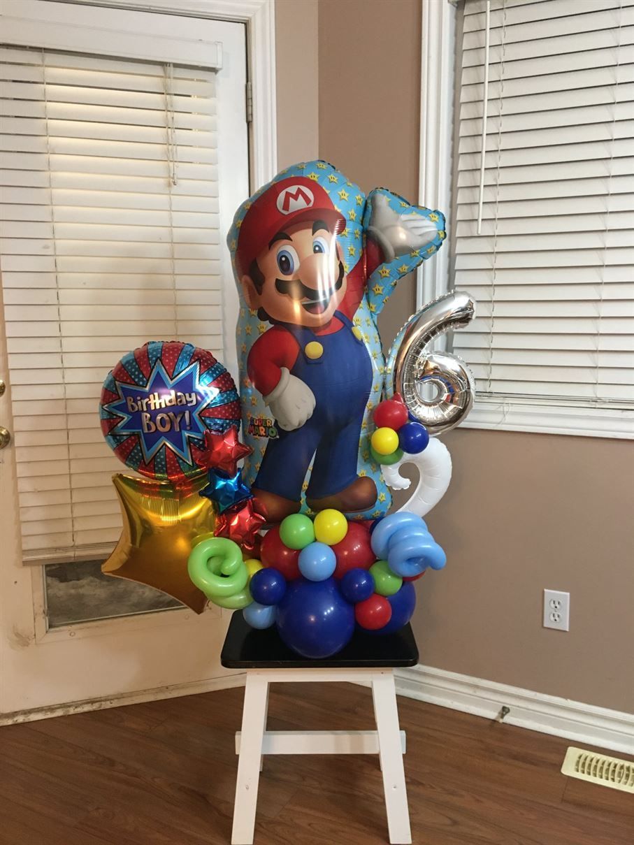 A bunch of balloons are sitting on a stool in a room.