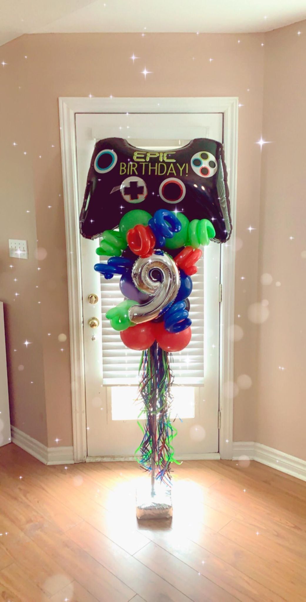 A bunch of balloons are sitting on top of a wooden floor in a room.