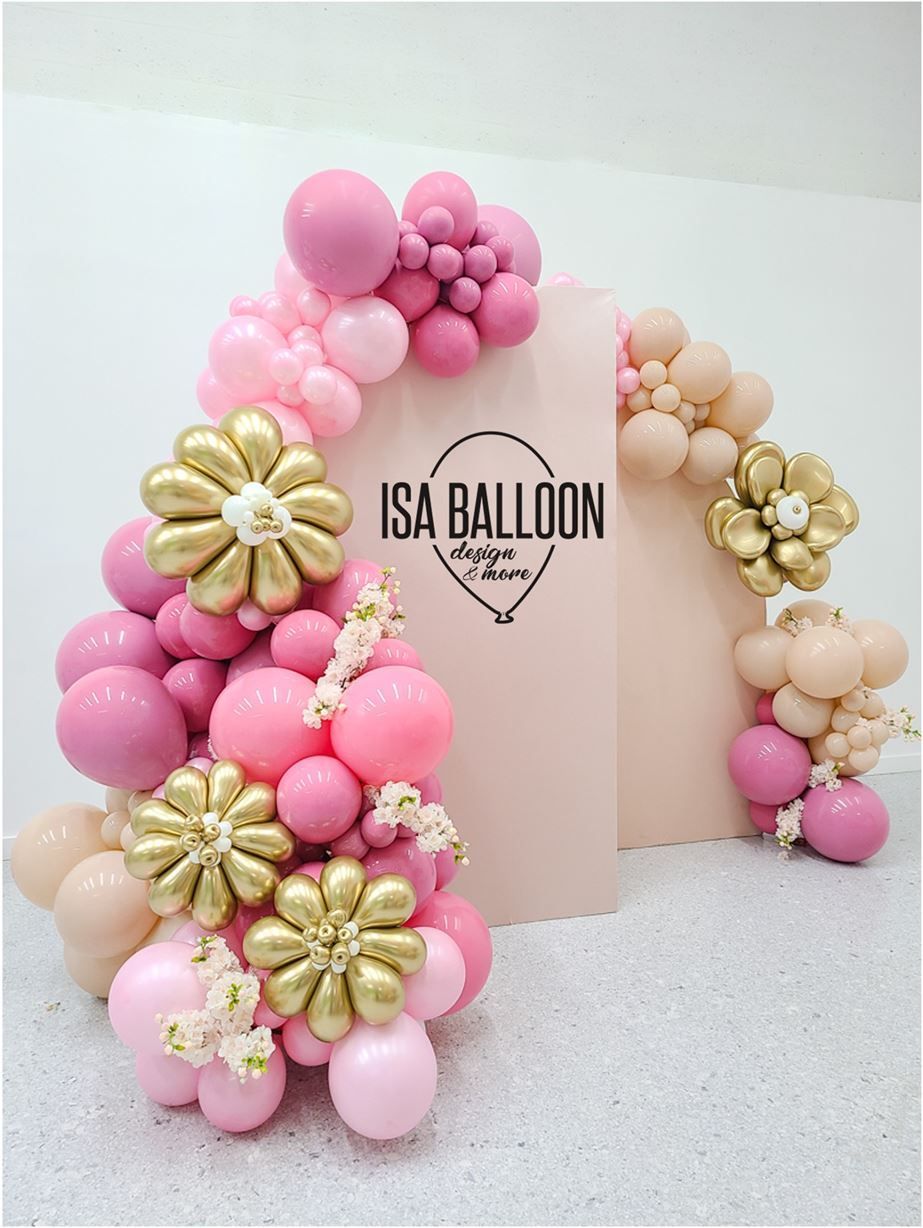 A bunch of pink and gold balloons are sitting on a table.