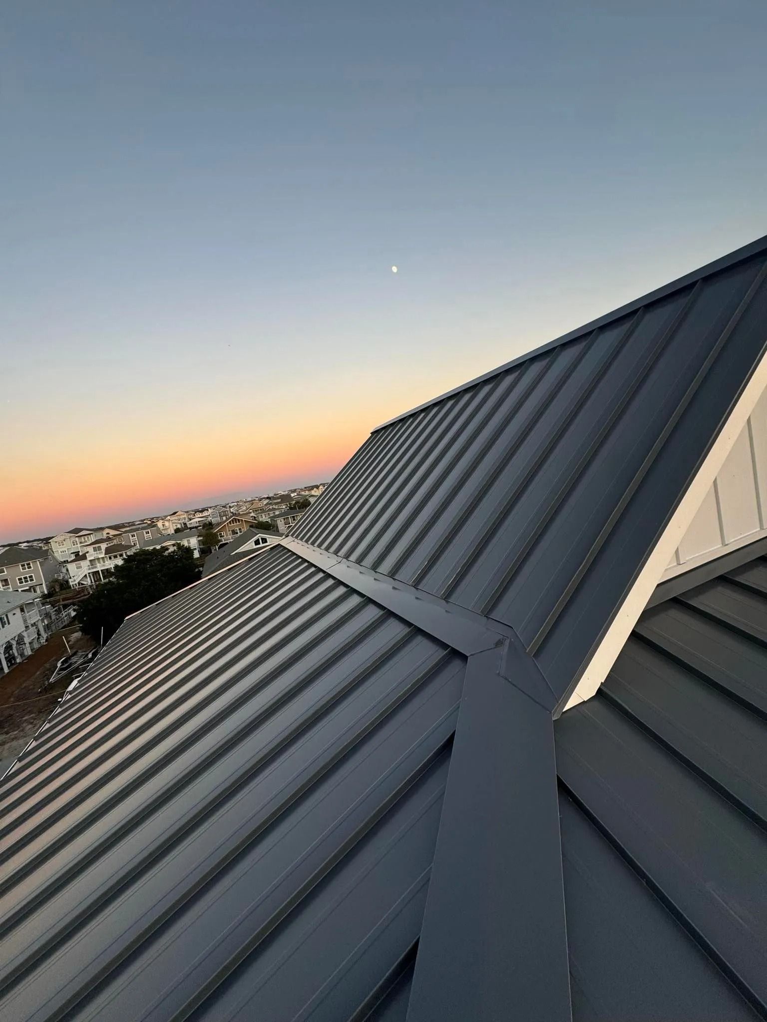Metal rooftop at sunset with city skyline and pastel sky in the background