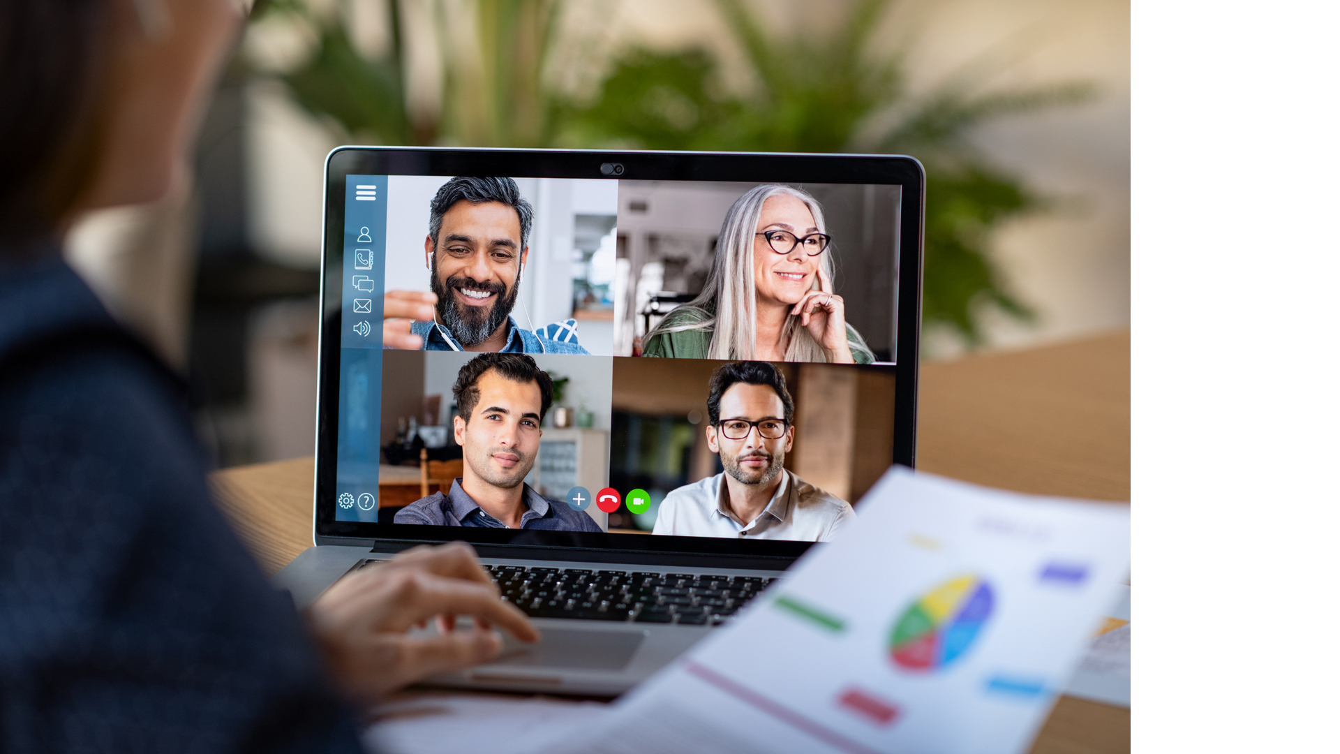 Person in a video conference with colleagues, reviewing a chart on paper.
