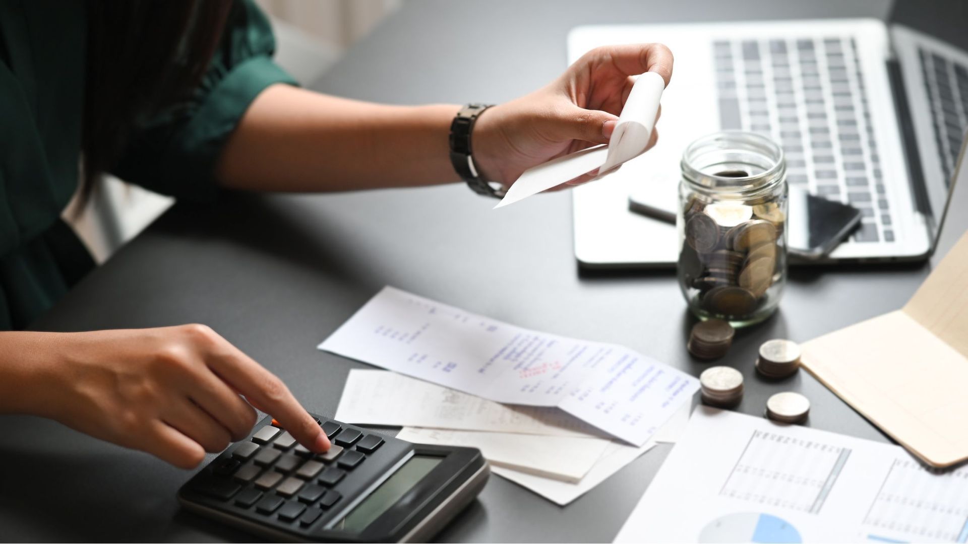 A woman is using a calculator to calculate her bills.