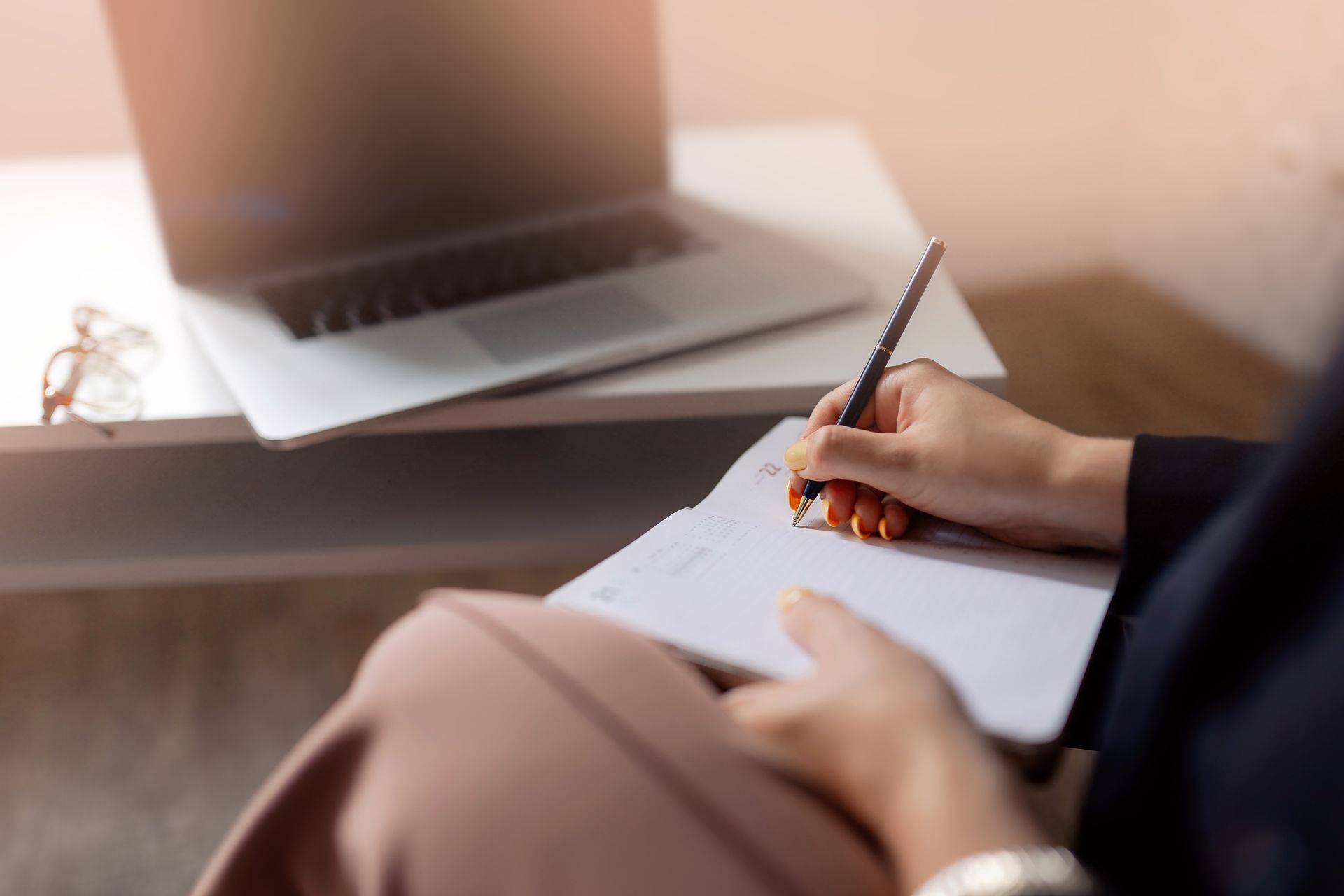 Closeup of a psychiatrist taking notes in notebook during online consultation. Closeup of a psychiatrist taking notes in notebook during online consultation.