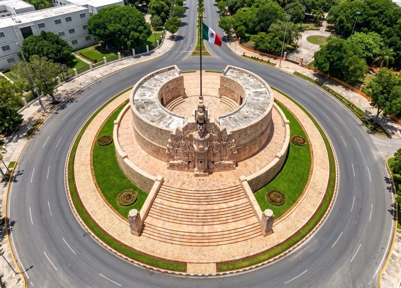 Aerial view of a circular stone monument in a landscaped roundabout with trees and roads around it