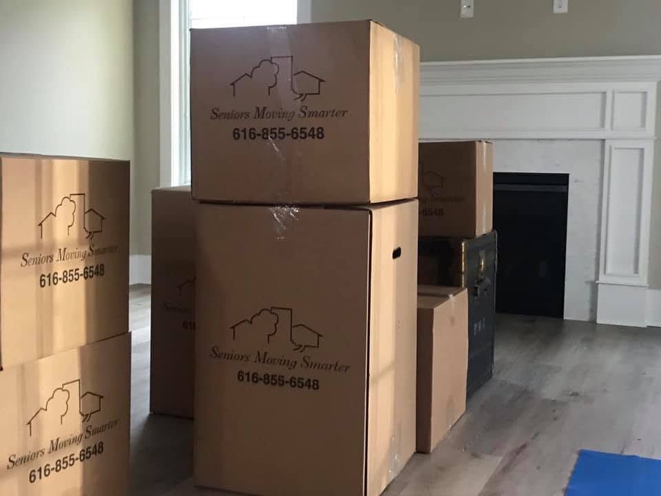 Stacks of moving boxes in a room, labeled with a house logo and phone number.
