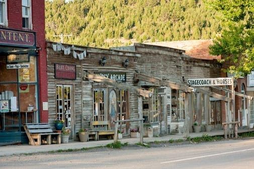 Weathered old storefronts lining a quiet street in a rustic mountain town