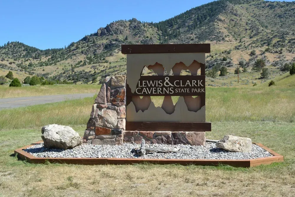 Lewis and Clark Caverns State Park sign in a grassy mountain landscape