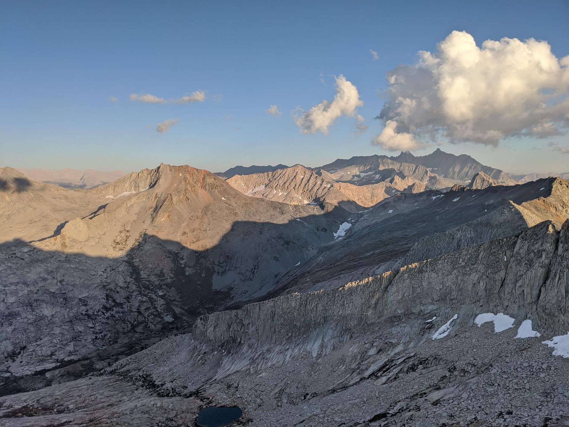 Rocky mountain ridge under a blue sky with clouds at sunset