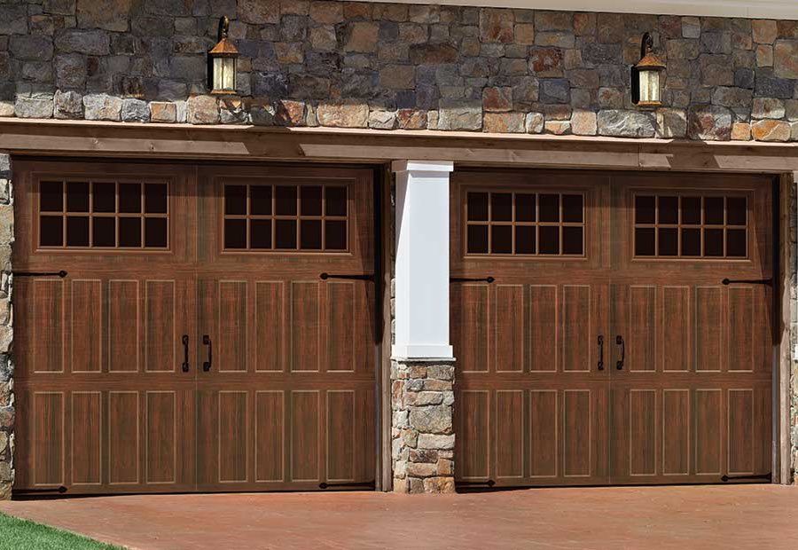 Twin wooden garage doors with stone and white trim on a brick driveway, viewed front-on.
