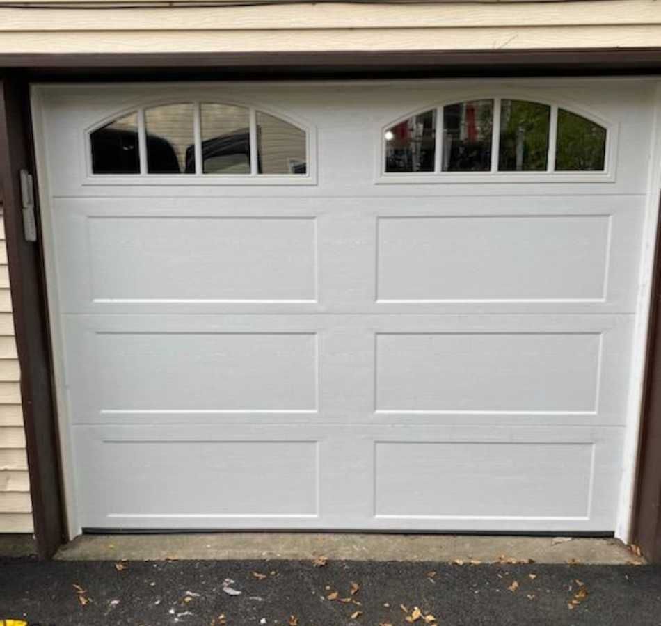 White double garage door with small arched windows at the top.