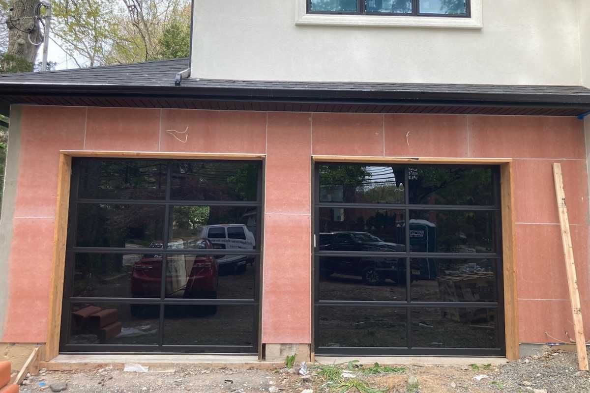 Storefront with two large black-framed windows beneath a pink facade and beige upper wall