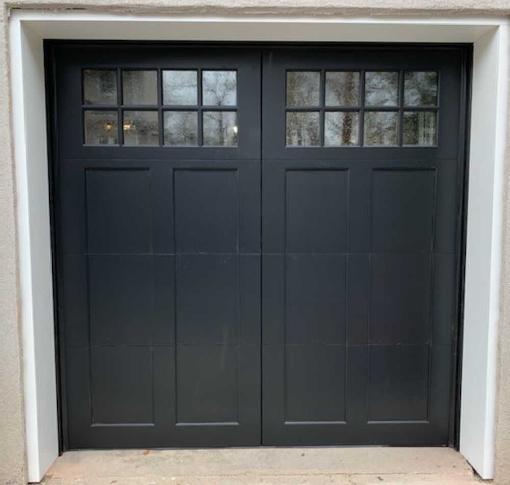 Dark gray two-car garage door with small window panes at the top.