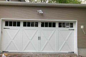 White double garage doors on a tan house exterior