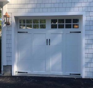 White double garage door with small upper windows on a house exterior