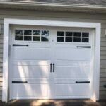 White garage door with windows in a light gray house exterior