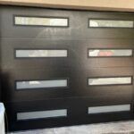 Black front door with six horizontal frosted glass mail slots and silver handles.