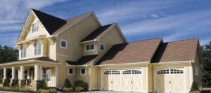 Cream-colored two-story house with attached garage under a blue sky